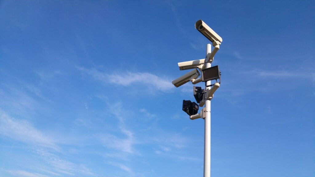 Crafting Captivating Headlines: Your awesome post title goes here Multiple security cameras on a pole with a clear blue sky backdrop.